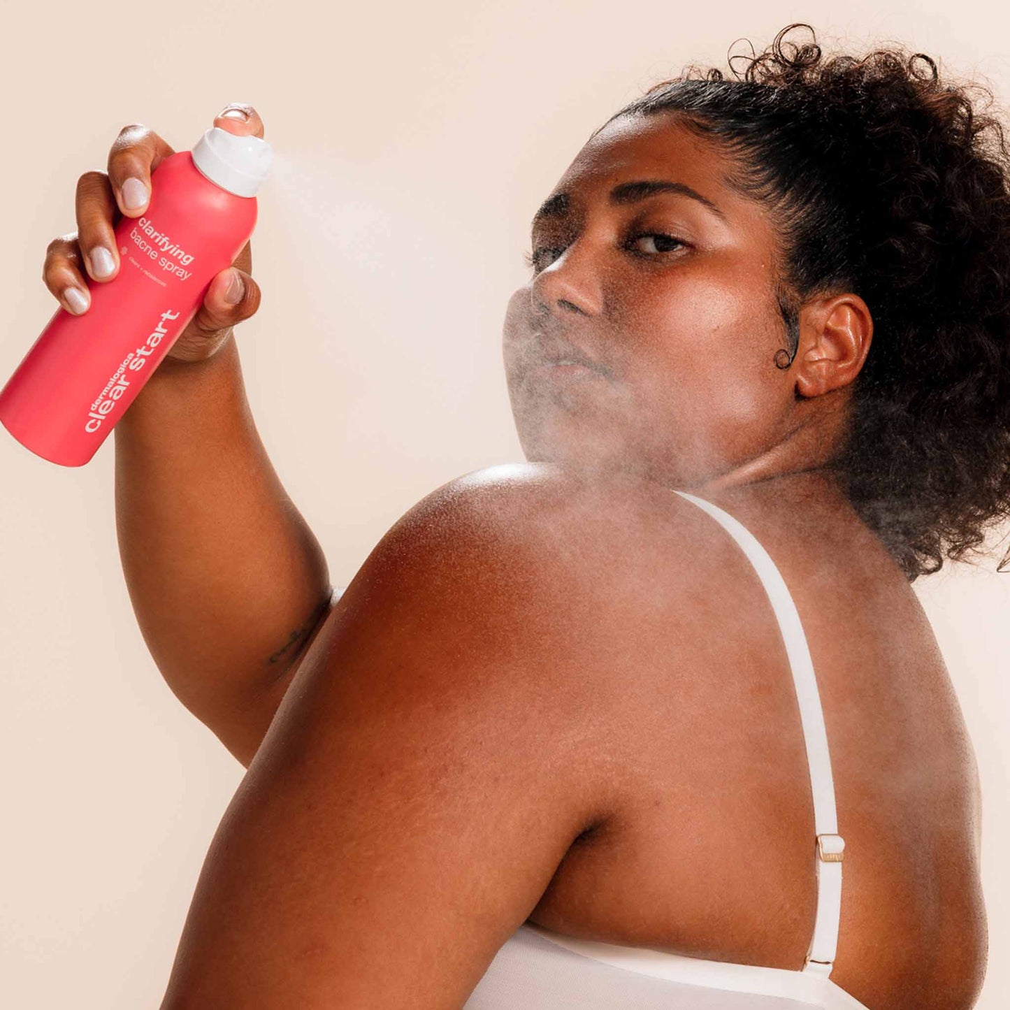 Model spraying Clarifying Bacne Spray on back 